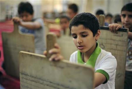 Libyan boys are seen with wooden slates as they memorize scriptures from the Koran at a school in Benghazi