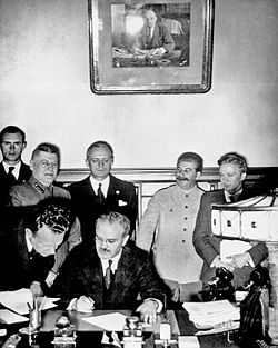 Молотов подписва пакта за ненападение между Германия и СССР. На заден план са Рибентроп и Сталин.