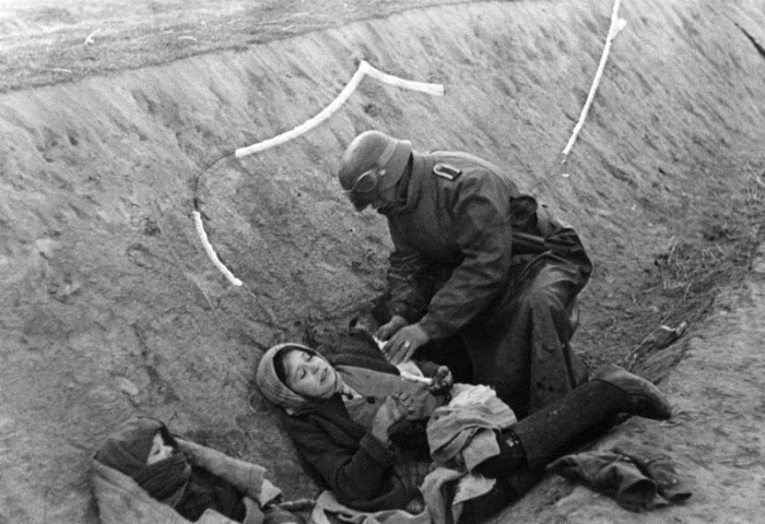 ВСВ. Немски войник помага на ранени руски цивилни граждани.